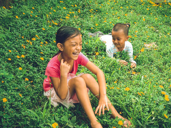 Siblings sitting on grass