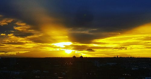 Scenic view of dramatic sky over city during sunset