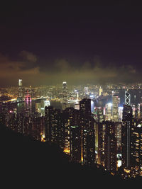 Illuminated cityscape against sky at night