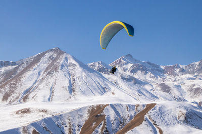 Scenic view of snowcapped mountains against clear blue sky