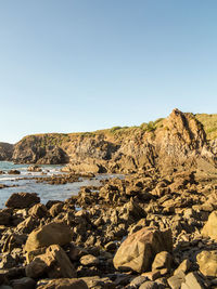 Rocks on beach against clear sky