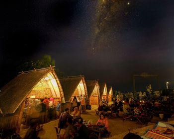 People sitting in illuminated building at night