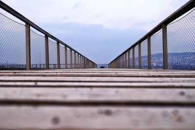 Surface level of footbridge against sky