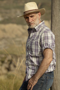 Portrait of adult man in sun hat and shirt in desert