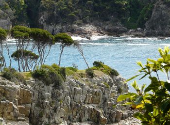 Rock formation by sea against sky