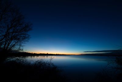 Scenic view of lake against blue sky at sunset