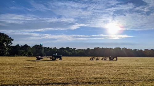 Farm equipment on field against sky