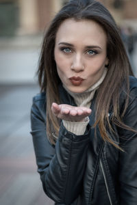 Portrait of beautiful woman blowing a kiss during winter