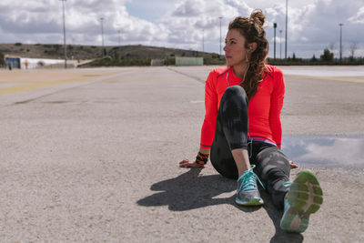 Full length of woman sitting on road