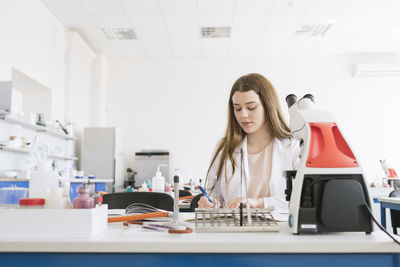 Young researcher in white coat working in a lab