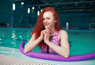Portrait of smiling woman with inflatable in swimming pool