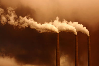 Smoke emitting from chimney against sky