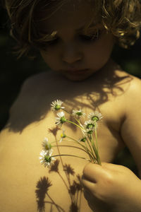 Boy with flowers shadows in golden light 