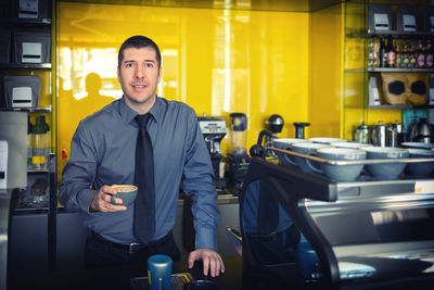 Portrait of young man standing in office