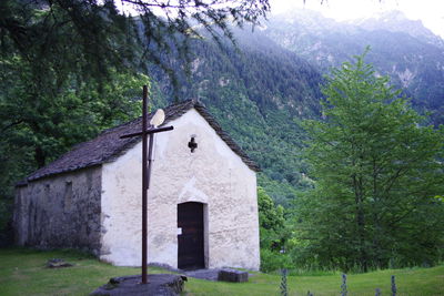 House amidst trees and buildings against sky