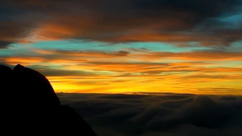 Silhouette person against sky during sunset