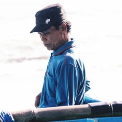 Side view of man wearing hat against sky