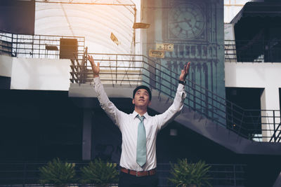Young man standing against building