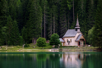 View of lake by trees and house in forest