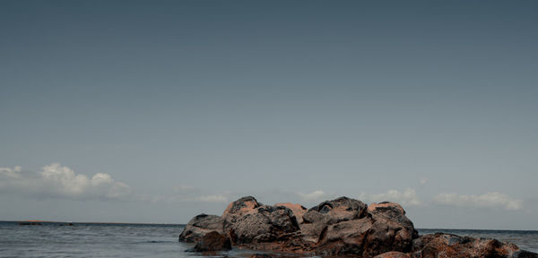 Rocks by sea against sky