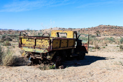 Abandoned truck on field against sky