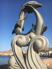 Close-up of sculpture against clear blue sky