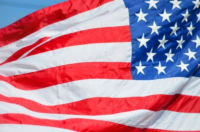 Low angle view of flag against blue sky