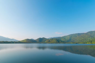 Scenic view of lake and mountains against blue sky