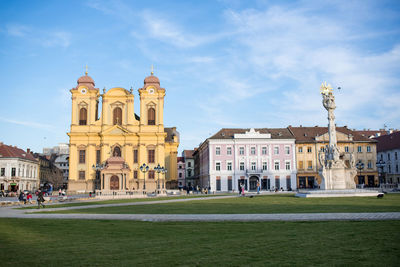 Buildings in city against cloudy sky