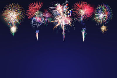 Low angle view of firework display at night