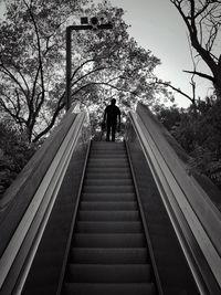 Low angle view of people walking on footbridge