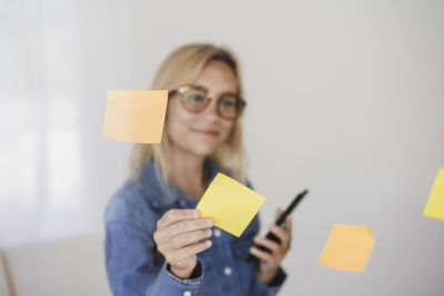 Freelancer sticking adhesive notes on glass