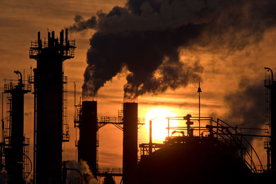 Silhouettes of sunrise and oil refineries