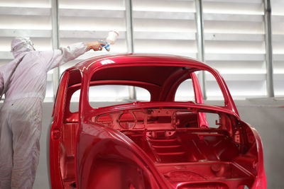 Man holding red vintage car