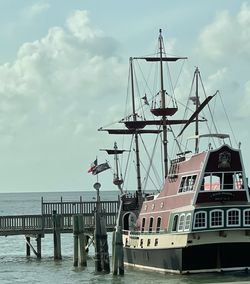 Ship moored at harbor against sky