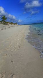 Scenic view of beach against blue sky