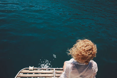 Rear view of woman standing against river