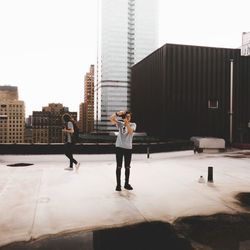 Men standing on city against sky