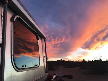Cars on road against sky during sunset