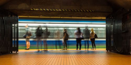 Blurred motion of people standing at subway station