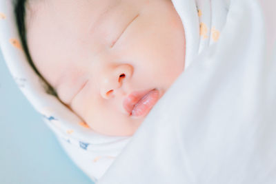 Close-up of newborn wrapped in blanket