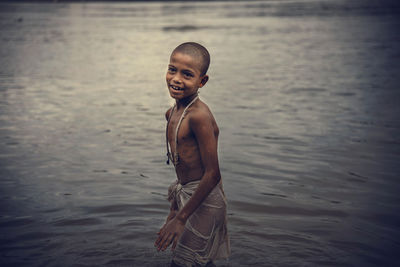 Portrait of shirtless boy standing in sea