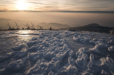 Aerial view of frozen sea against sky during sunset