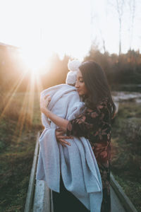 Woman embracing son during sunset