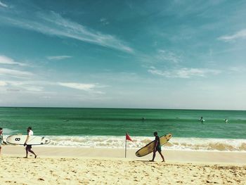 People on beach against sky