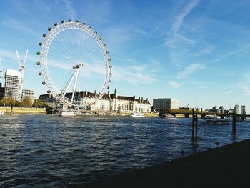 Ferris wheel by sea against sky