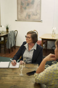 Woman with notebook and champagne glass on table