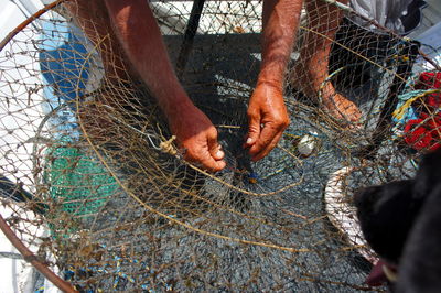 Low section of fisherman weaving fishing net