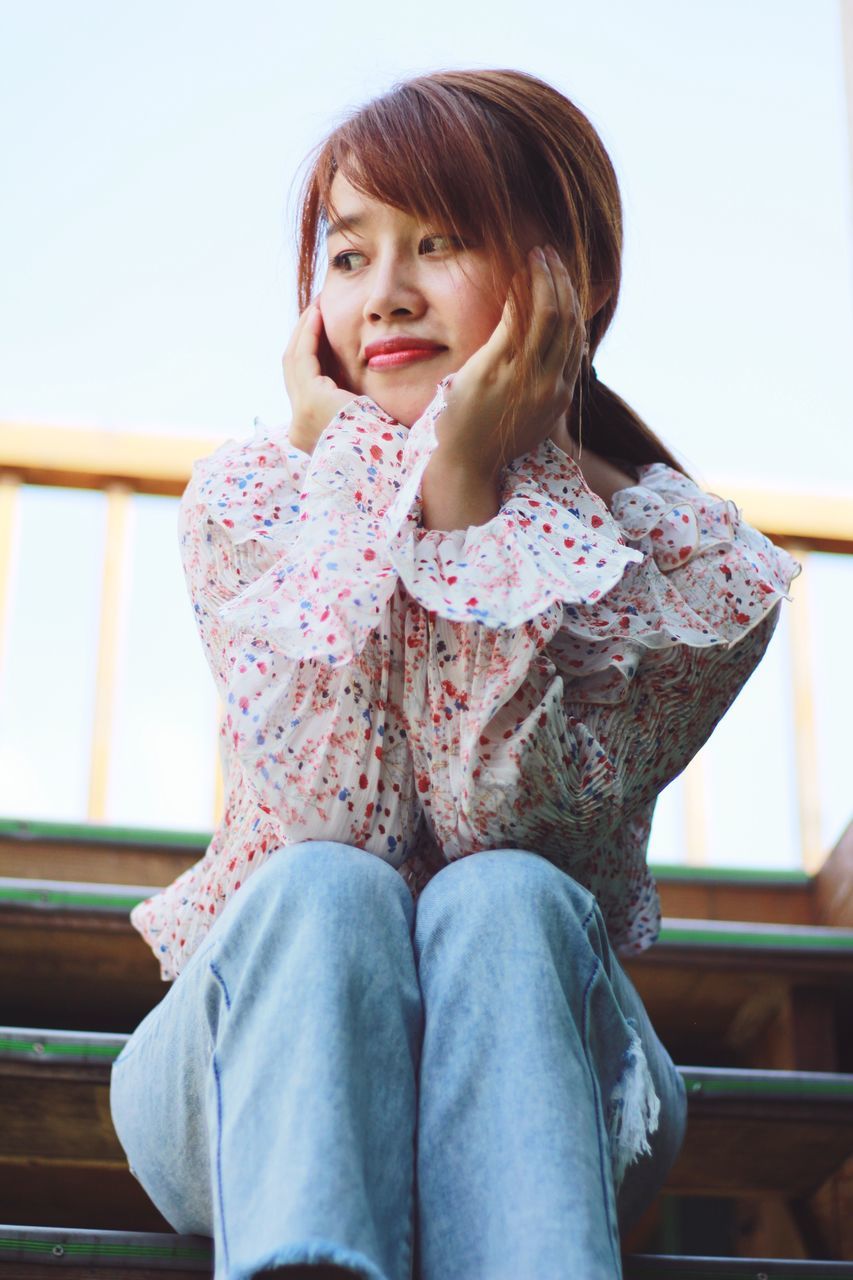 sitting, one person, casual clothing, three quarter length, childhood, real people, looking at camera, focus on foreground, leisure activity, young adult, portrait, indoors, day, young women