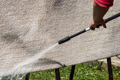 Midsection of person holding umbrella on land